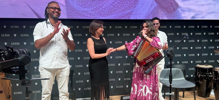 Embajadora de Colombia saludando a los artistas en el escenario